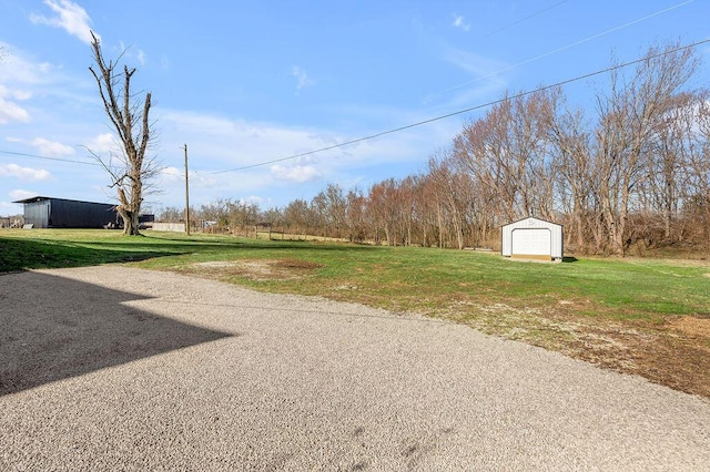 view of yard with an outbuilding, driveway, and a garage