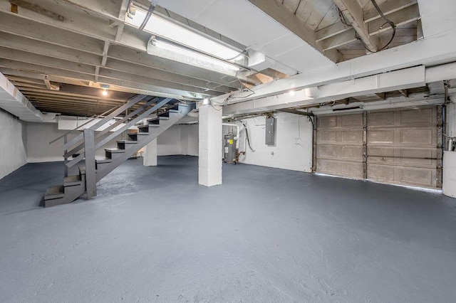 unfinished basement with stairs, electric panel, and electric water heater