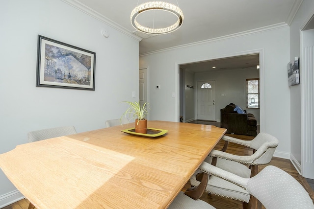 dining space with ornamental molding, dark wood finished floors, and baseboards