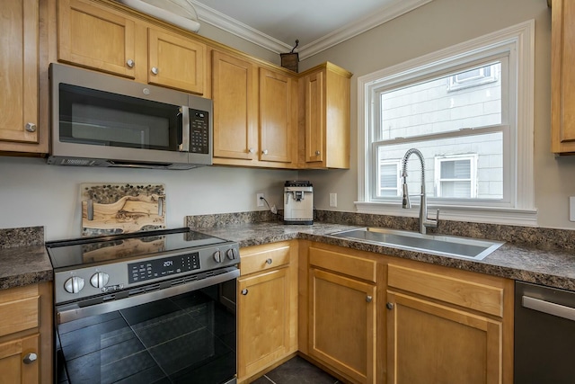 kitchen with ornamental molding, appliances with stainless steel finishes, dark countertops, and a sink