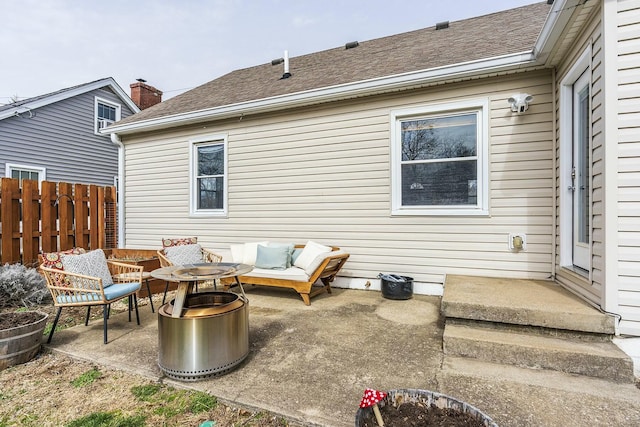 rear view of house with a shingled roof, fence, and a patio