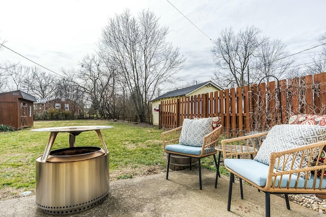 view of yard featuring a storage shed, fence, a patio, and an outbuilding