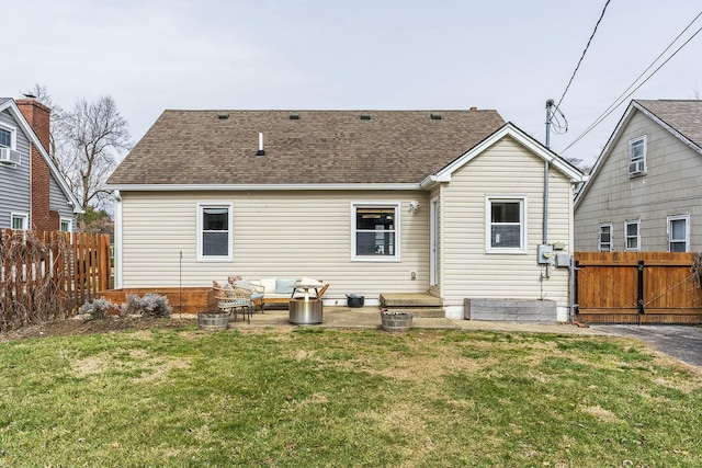 back of house featuring a yard, a shingled roof, a patio, and fence