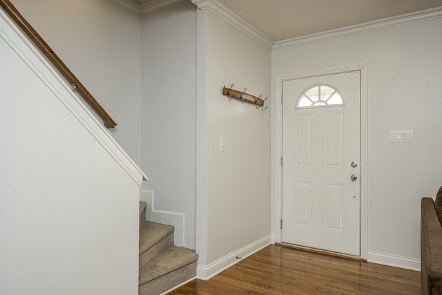 foyer featuring stairs, baseboards, wood finished floors, and crown molding