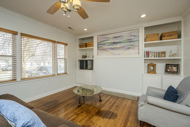 sitting room featuring visible vents, crown molding, baseboards, and wood finished floors