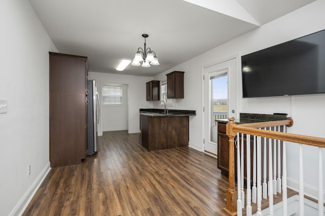 kitchen with a healthy amount of sunlight, dark brown cabinets, freestanding refrigerator, dark wood-style floors, and dark countertops