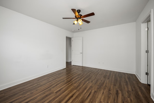 empty room with a ceiling fan, dark wood finished floors, and baseboards