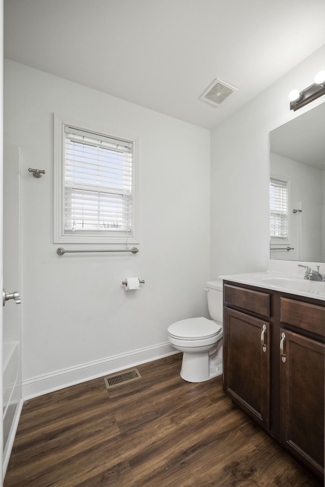 full bathroom with visible vents, vanity, toilet, and wood finished floors