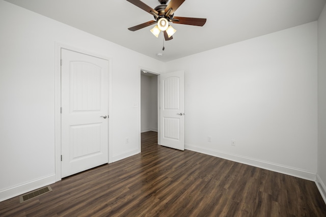 unfurnished bedroom featuring visible vents, dark wood finished floors, baseboards, and ceiling fan