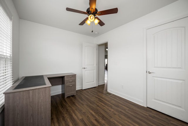 unfurnished office with ceiling fan, baseboards, and dark wood finished floors