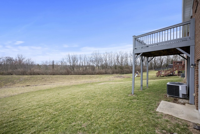 view of yard featuring stairs, a deck, and central AC unit