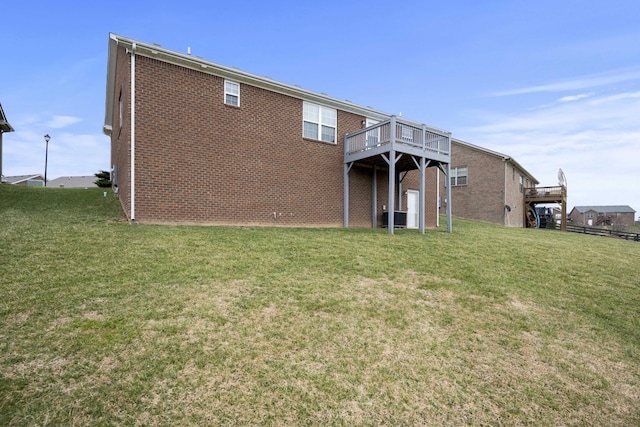 back of house with brick siding, central AC unit, a deck, and a yard