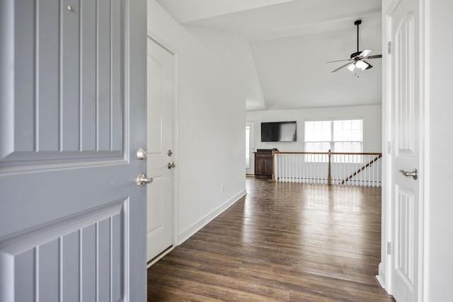 foyer entrance with a ceiling fan, vaulted ceiling, baseboards, and wood finished floors