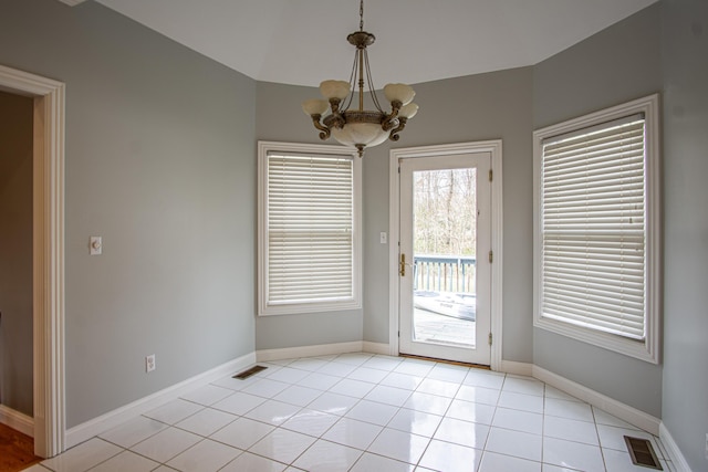 entryway with light tile patterned floors, baseboards, visible vents, and a chandelier