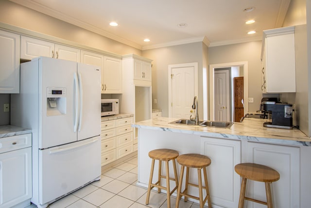 kitchen featuring white appliances, a peninsula, crown molding, white cabinetry, and a sink