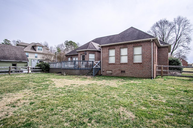 rear view of property with crawl space, a yard, and brick siding