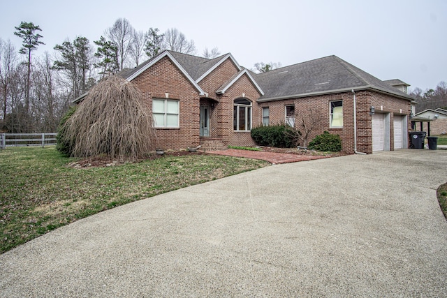 ranch-style home featuring brick siding, a shingled roof, concrete driveway, an attached garage, and fence