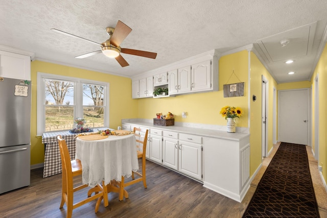 kitchen with light countertops, freestanding refrigerator, white cabinets, and dark wood-style floors