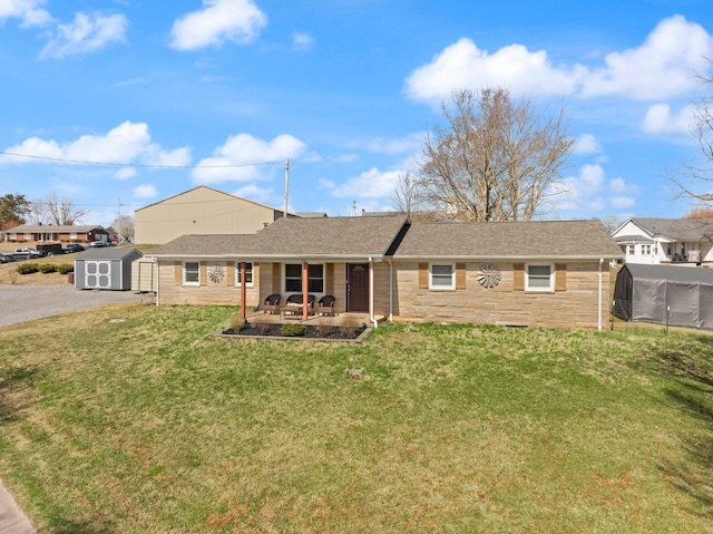 ranch-style home with a patio, a shingled roof, a storage shed, an outdoor structure, and a front lawn