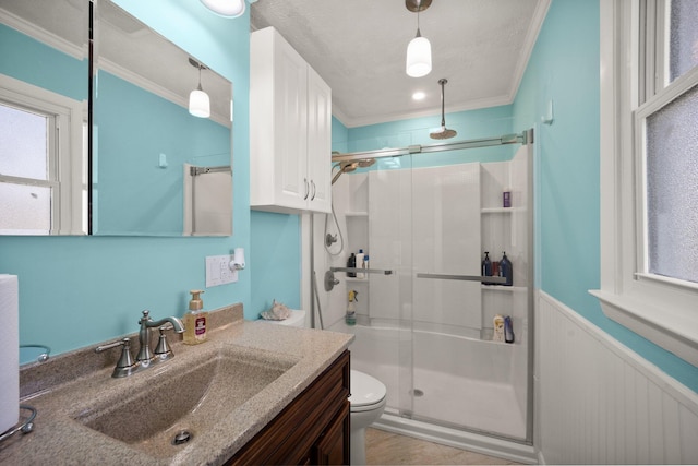 full bath with wainscoting, toilet, crown molding, vanity, and a shower stall