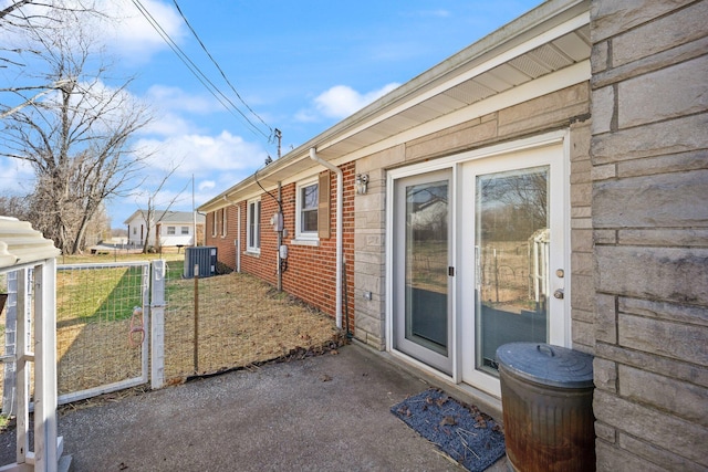 view of side of home featuring brick siding and central AC unit