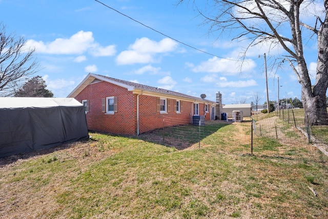 back of house with a yard and brick siding