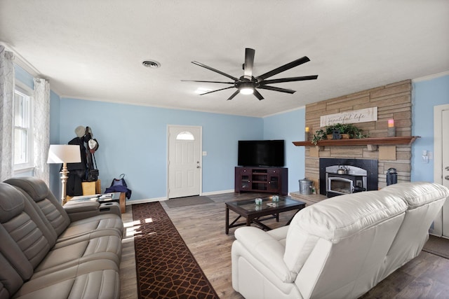 living room featuring baseboards, visible vents, ceiling fan, wood finished floors, and crown molding