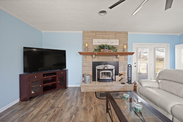 living area featuring ornamental molding, wood finished floors, visible vents, and baseboards