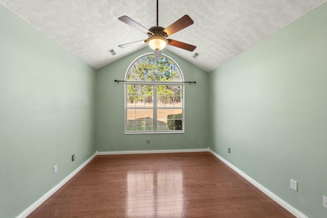 spare room with baseboards, a textured ceiling, visible vents, and wood finished floors