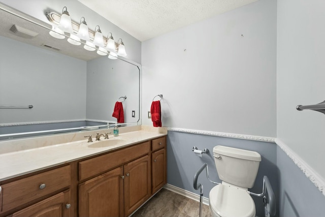 bathroom featuring visible vents, toilet, a textured ceiling, and vanity