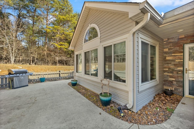 view of home's exterior featuring a patio and fence