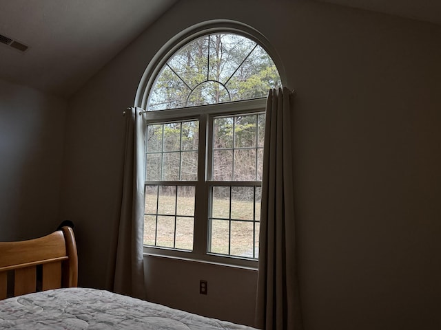 bedroom featuring lofted ceiling and visible vents