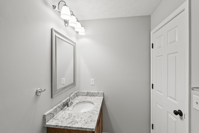 bathroom with a textured ceiling and vanity