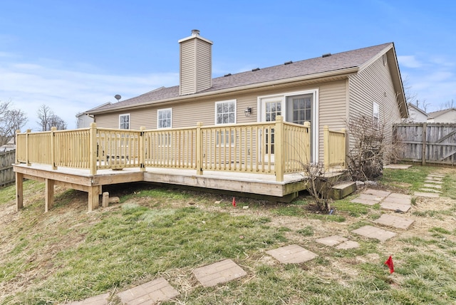 back of property featuring a deck, a fenced backyard, a lawn, and a chimney