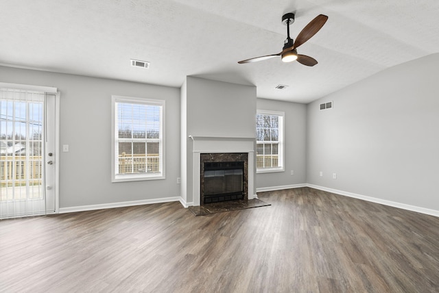 unfurnished living room featuring visible vents, a fireplace, and wood finished floors