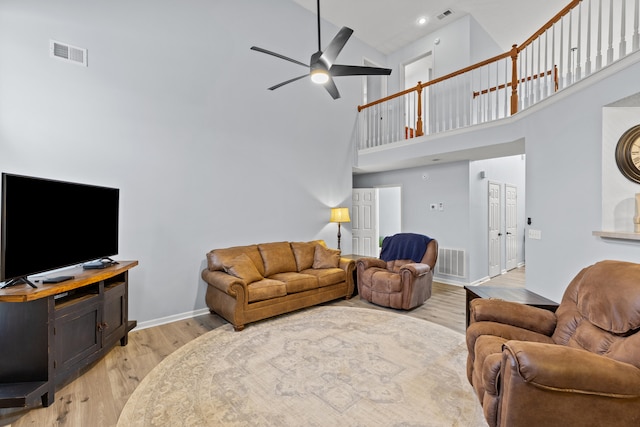 living area featuring light wood-style flooring, visible vents, and baseboards