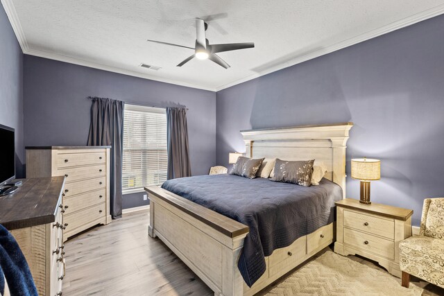 bedroom with visible vents, a ceiling fan, ornamental molding, wood finished floors, and a textured ceiling