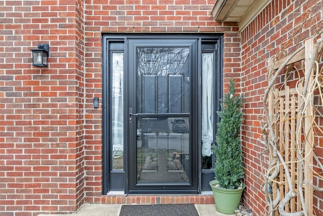 doorway to property with brick siding