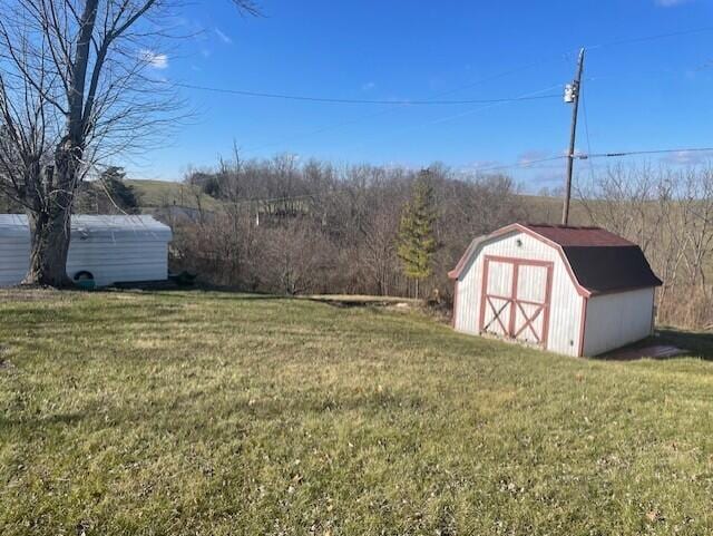 view of yard with a storage shed, an outbuilding, and a detached garage