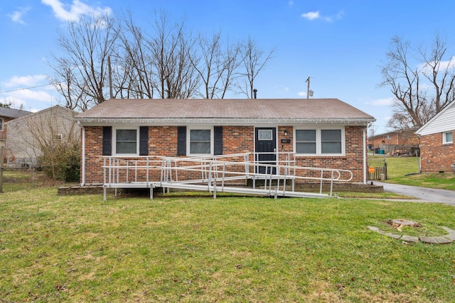 ranch-style house featuring brick siding, a porch, a front yard, and fence