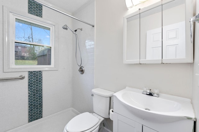 full bath featuring toilet, a tile shower, and vanity