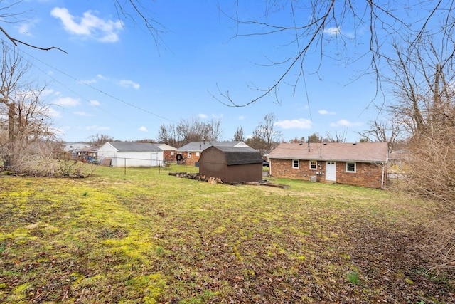 view of yard featuring a storage unit, an outdoor structure, and fence