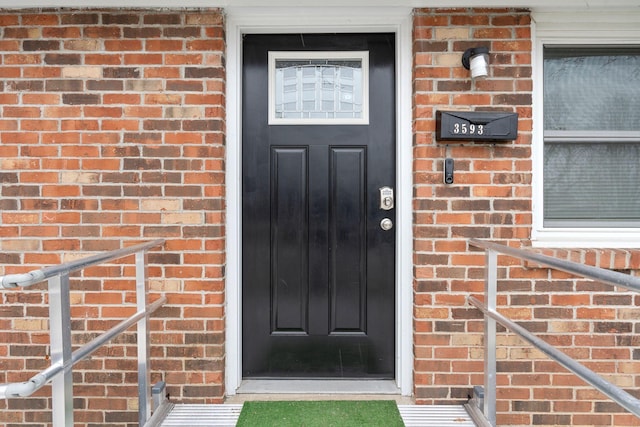 doorway to property with brick siding