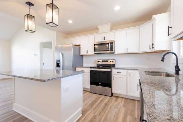 kitchen featuring light wood finished floors, white cabinetry, stainless steel appliances, and a sink