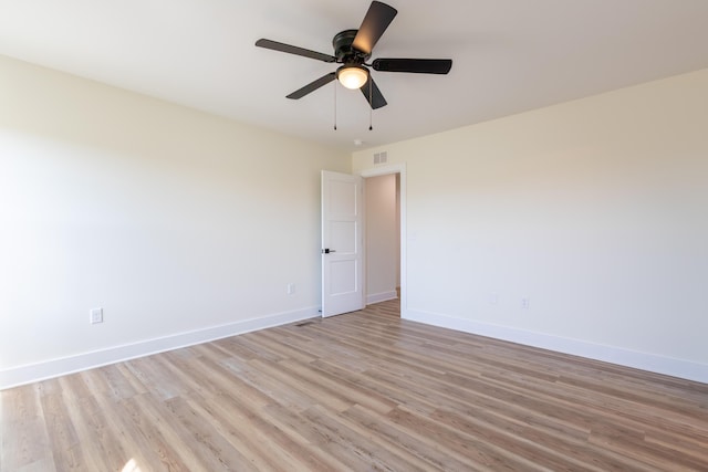 spare room with light wood-style floors, visible vents, baseboards, and ceiling fan