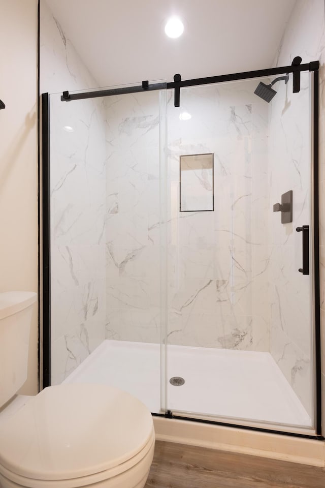 full bath featuring a marble finish shower and toilet