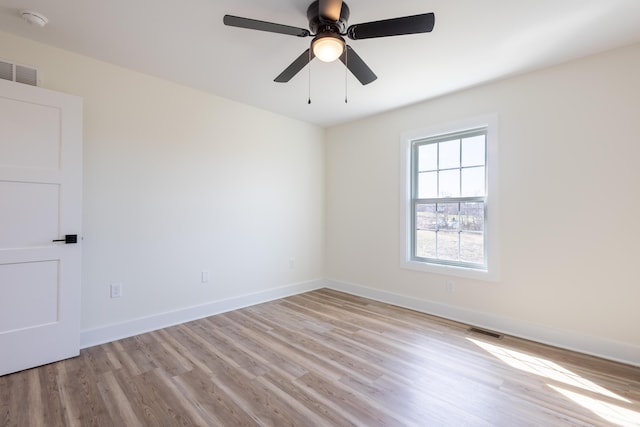 unfurnished room with visible vents, ceiling fan, baseboards, and wood finished floors