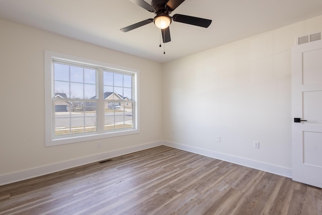 spare room with visible vents, light wood-style flooring, and baseboards