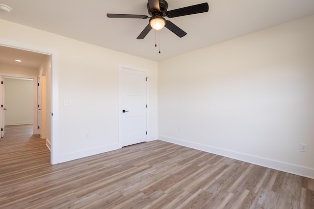 interior space featuring light wood-type flooring, baseboards, and a ceiling fan