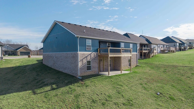 rear view of house featuring a lawn, a patio, a residential view, a wooden deck, and brick siding